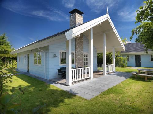 a white house with a chimney and a patio at De Gouden Spar in Noordwijk