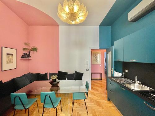 a kitchen with pink and blue walls and a table and chairs at ALMA de Toledo Design Home Plebiscito in Naples