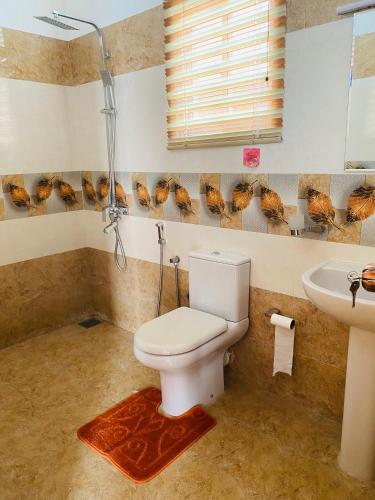 a bathroom with a toilet and a sink at The Kingslayer Resort in Negombo