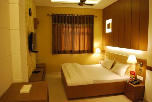 um quarto de hotel com uma cama e uma janela em Hotel Arina Inn em Nova Deli