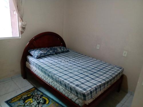 um pequeno quarto com uma cama num quarto em Casa a 40 metros da praia em Governador Celso Ramos