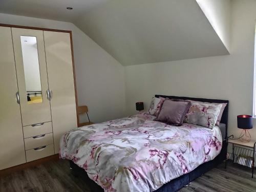 a bedroom with a bed and a dresser at Ballymakeever Apartment And Spa in Derry Londonderry