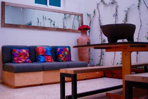 a living room with a blue couch with colorful pillows at Casa RM26 CoLiving & Travel Roma Norte, CDMX in Mexico City