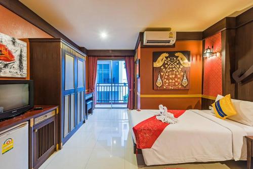 パトンビーチにある99 Residenceのベッドとテレビがあるホテルの部屋