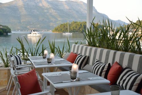 a restaurant with tables and chairs with a view of the water at Tara's Lodge in Korčula