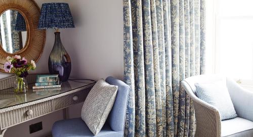 a living room with a chair and a mirror at Red Lion Hotel in Clovelly