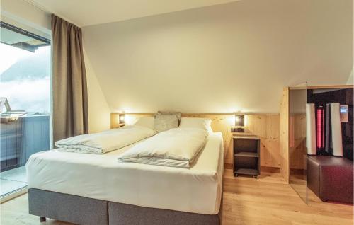 a bedroom with a large white bed and a window at Schoene Ferienwohnung Zams in Zams