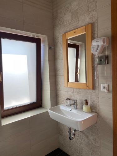 a bathroom with a sink and a mirror at Villa Montana Borsec - Vedere Munte in Borsec