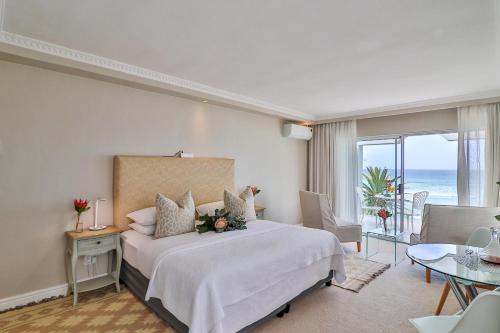 - une chambre avec un lit et une vue sur l'océan dans l'établissement Hermanus Beachfront Lodge - Solar Power, à Hermanus