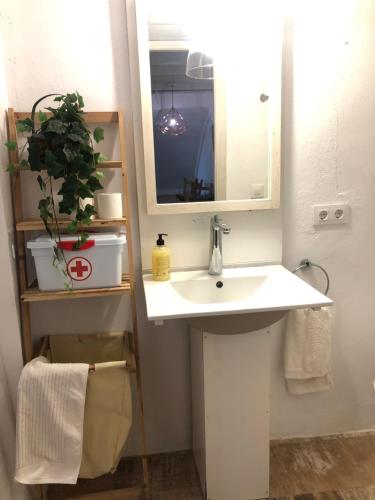 W łazience znajduje się biała umywalka i lustro. w obiekcie Casa de la vega w mieście Almodóvar del Río