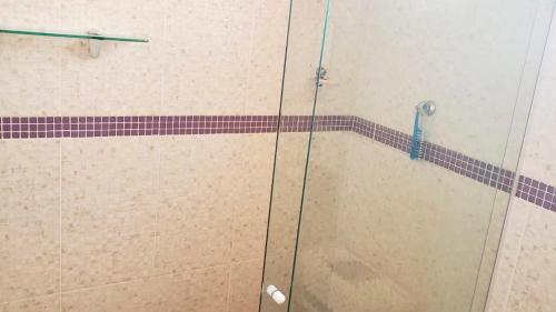 una doccia con porta in vetro in bagno di Casa da Dinda à 650m da praia de Itaúna a Saquarema