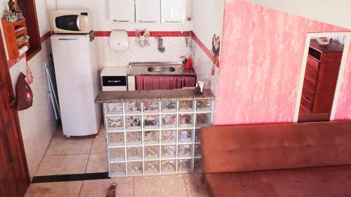 a small kitchen with a sink and a refrigerator at Casa da Dinda à 650m da praia de Itaúna in Saquarema