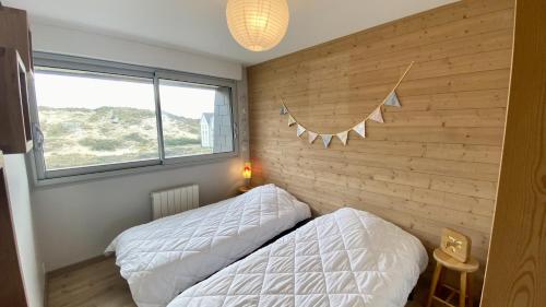 sypialnia z dwoma łóżkami i ceglaną ścianą w obiekcie Appartement vue mer, Brigantine w mieście Fort-Mahon-Plage