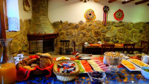 una mesa con un buffet de comida y una chimenea en Picaflor Tambo Guest House, en Ollantaytambo