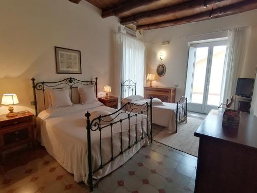 a bedroom with two beds and a large window at B&B Palazzo Lanza in Capua