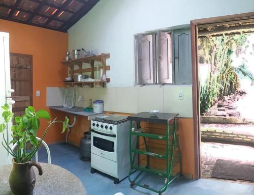 a kitchen with an oven and a table in a room at Casinhas Vila Bonita Azul in Baía Formosa