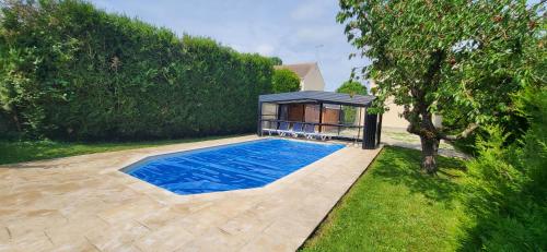 a swimming pool in a house with a gazebo at Nalan Johannisien, Maison piscine chauffée-Spa, Paris CDG-Disney in Jagny-sous-Bois