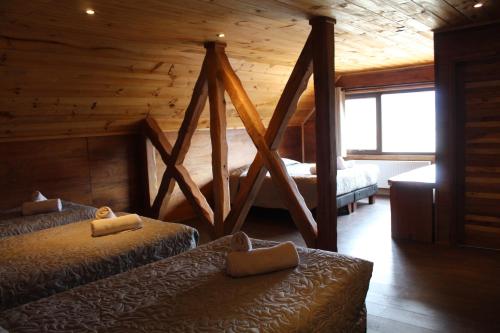 隆基邁的住宿－LONQUIMAY LODGE，小木屋内一间卧室,配有两张床