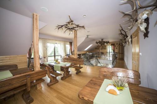 una grande stanza con panche e tavoli di legno di Restauracja Hotel Ostoja a Wieniawa