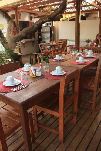 una mesa de madera con platos y servilletas. en Pousada Aroeira, en Caraíva