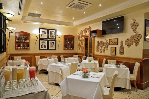 a dining room with white tables and chairs at Hotel Homs in Rome