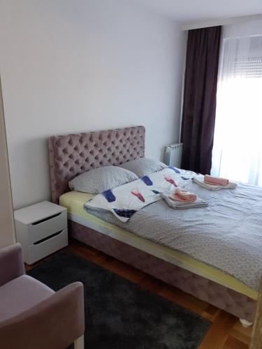Un dormitorio con una cama con toallas y una ventana. en Stan na dan VRŠAC, en Vršac