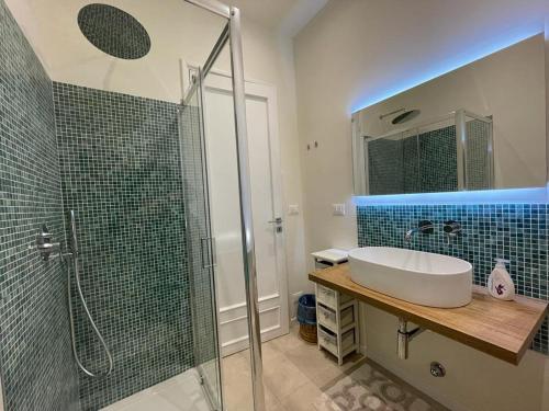 a bathroom with a sink and a glass shower at Address Home I Colori Del Mare in Ospedaletti