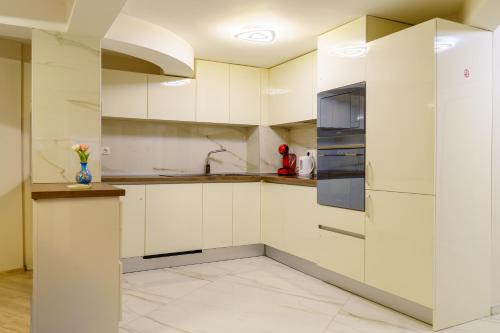a kitchen with white cabinets and stainless steel appliances at Centrally Located Apartment in Varna in Varna City
