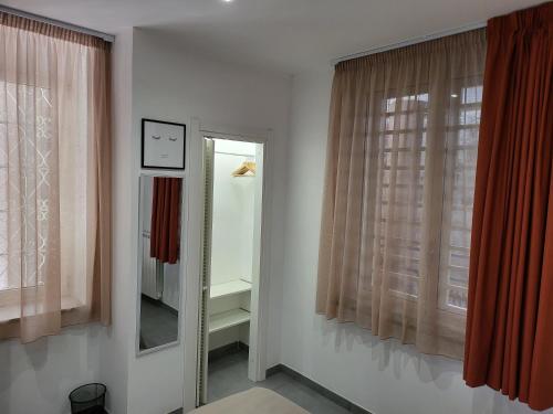 a room with two windows and a mirror at Casa Monì in Naples