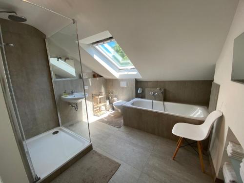 ein Badezimmer mit einer Dusche, einer Badewanne und einem Waschbecken in der Unterkunft Apartment Art in Bad Krozingen