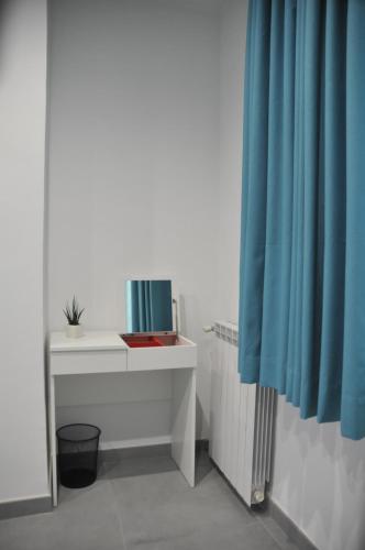 a bathroom with a white sink and a blue curtain at Casa Monì in Naples