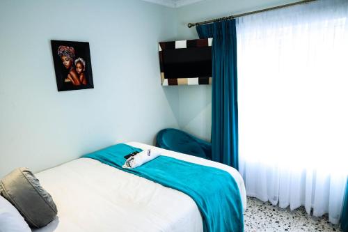 a small bedroom with a bed and a window at El-Gibor Best Guest House in Cape Town