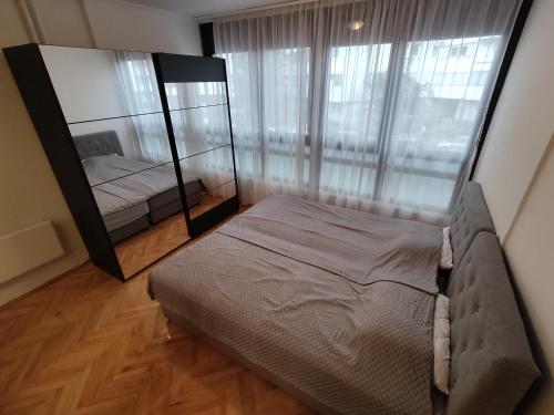 a bedroom with a large mirror and a bed at Apartment Alex in Banja Luka