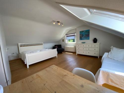 een slaapkamer op zolder met 2 bedden en een tafel bij Apartment Art in Bad Krozingen