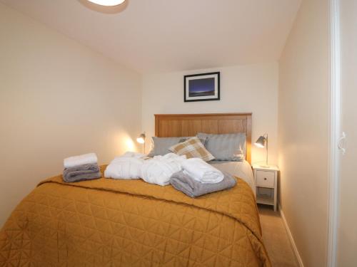 a bedroom with a bed with towels on it at Sportsmans Lodge in Kirriemuir