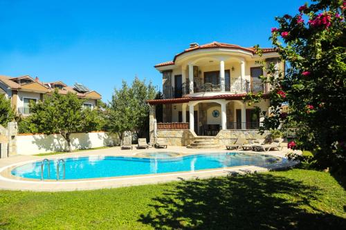 a large house with a swimming pool in front of it at Villa Ahmet Dalyan 4 bedrooms in Dalyan