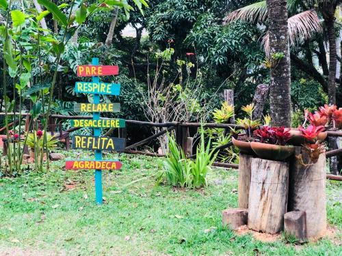 a sign in the grass with flowers in a garden at Pousada Nova Gironda in Paty do Alferes