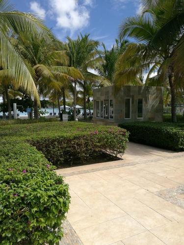 a building with palm trees in front of a courtyard at Playa Blanca SC in Río Hato