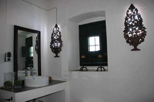 ein Badezimmer mit zwei Spiegeln, einem Waschbecken und einem Spiegel in der Unterkunft Casa das Moles in Évora