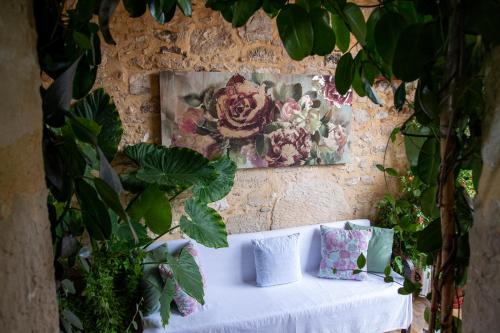 a stone wall with a white table with pillows and plants at Armonia Villa, Unsurpassed privacy at picturesque location, By ThinkVilla in Pasalítai