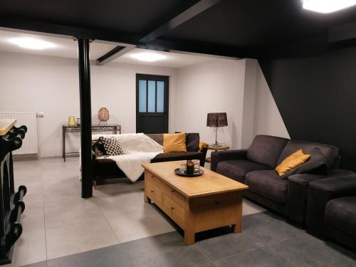 uma sala de estar com um sofá e uma mesa de centro em Gite Terre de ciel em Ferrières