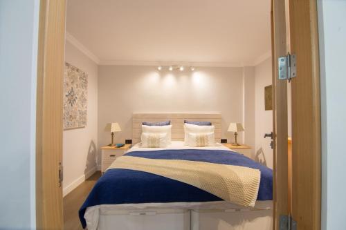 a bedroom with a bed with blue and white sheets at Edén del Mar in Puerto de la Cruz