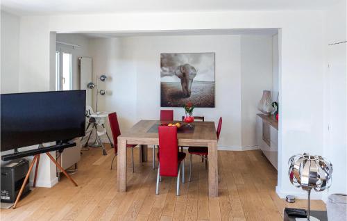 une salle à manger avec une table en bois et des chaises rouges dans l'établissement Amazing Apartment In Triel-Sur-Seine, à Triel-sur-Seine