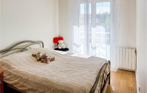 two teddy bears sitting on a bed in a bedroom at Amazing Apartment In Triel-sur-seine With 2 Bedrooms And Wifi in Triel-sur-Seine