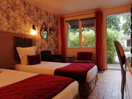 a hotel room with two beds and a window at Hôtel Monet in Honfleur