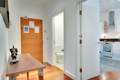 een keuken met een tafel en een deur naar een badkamer bij Crown Apartments 113 by Week2Week in Newcastle upon Tyne