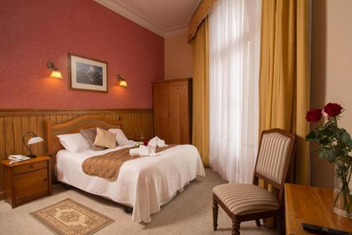 a bedroom with a bed and a table and a chair at Hotel Plaza in Punta Arenas