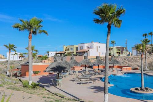 un complejo con una piscina con sombrillas y palmeras en Brand New Home - The Village in Las Conchas #38, en Las Conchas