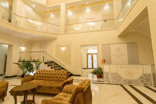 a lobby with couches and a staircase in a building at Osiyo Plaza Hotel in Samarkand