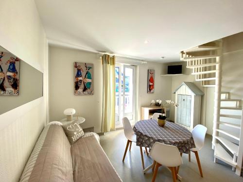 a living room with a table and chairs and a staircase at Résidence du Parad'Ice in Dinard